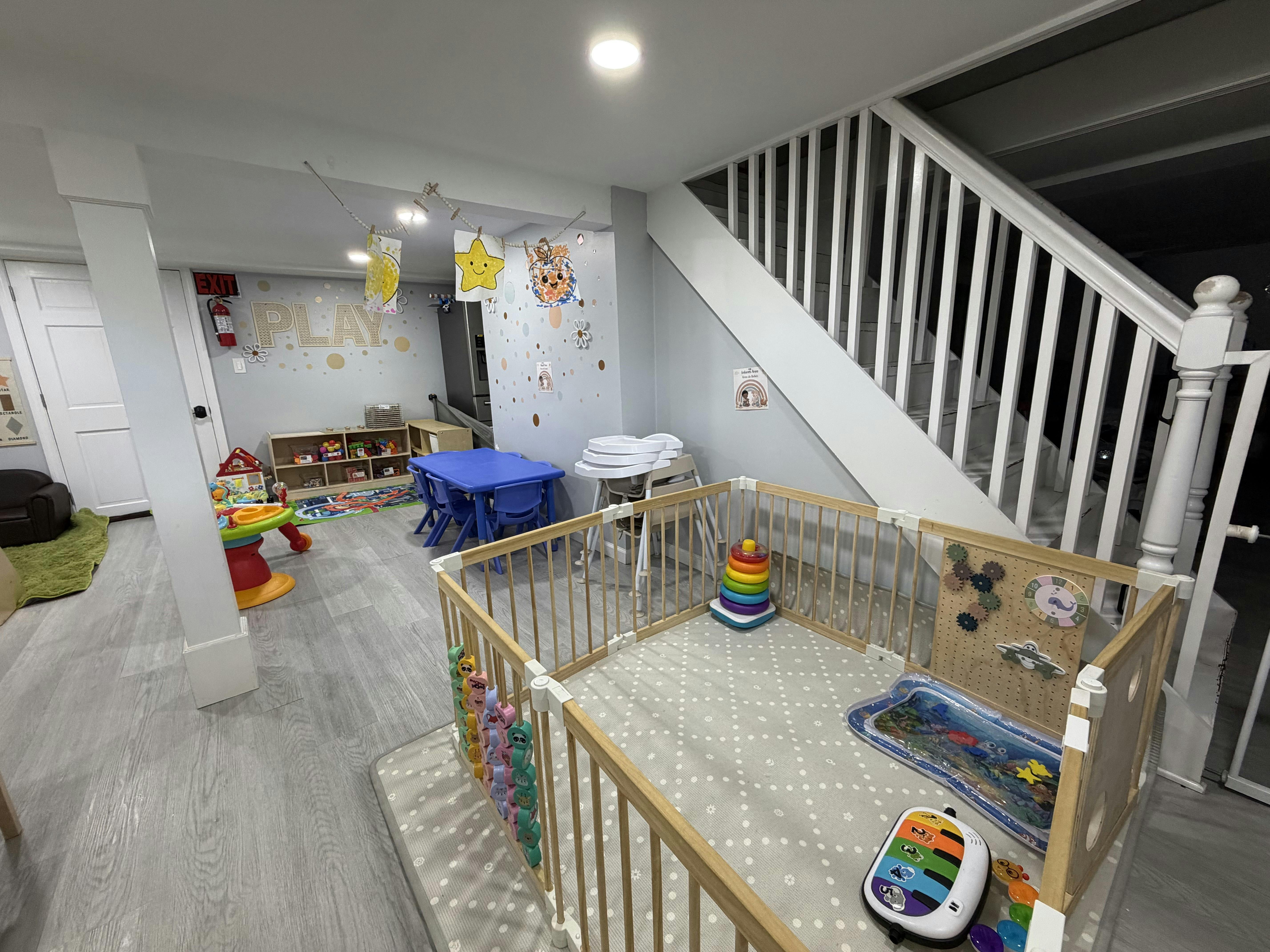 Playroom with a playpen, small table, and various children's toys
