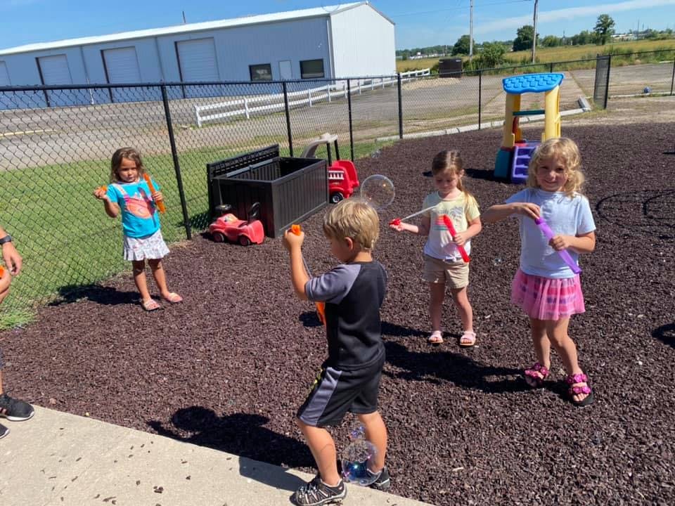 Children playing with bubbles outdoors