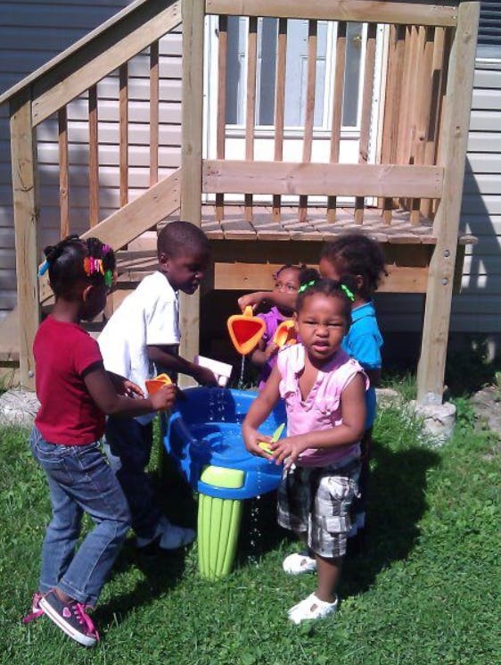 Children playing with a water table outdoors