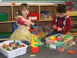 Two children playing with building blocks