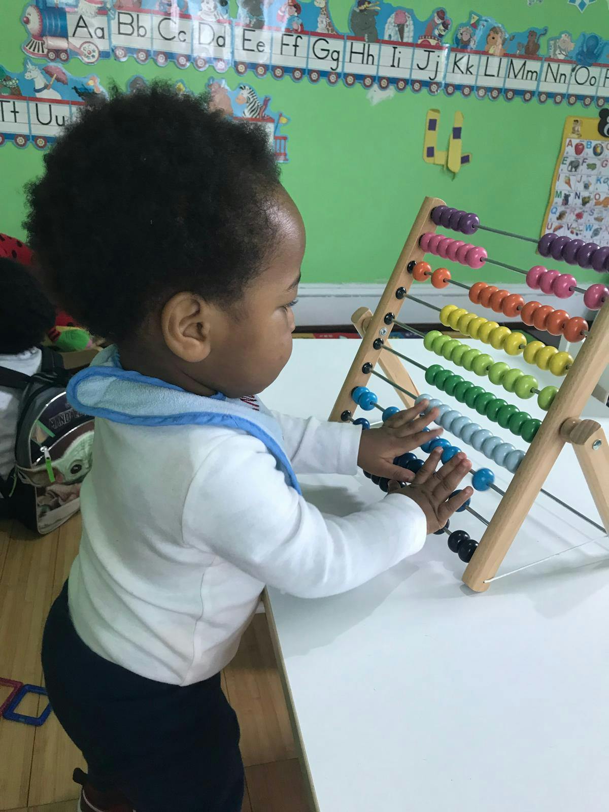 Child playing with a colorful abacus
