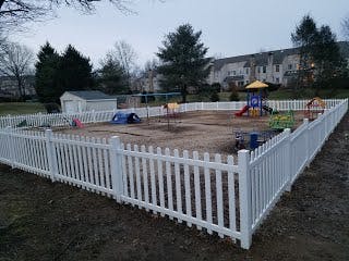 Playground with a white picket fence