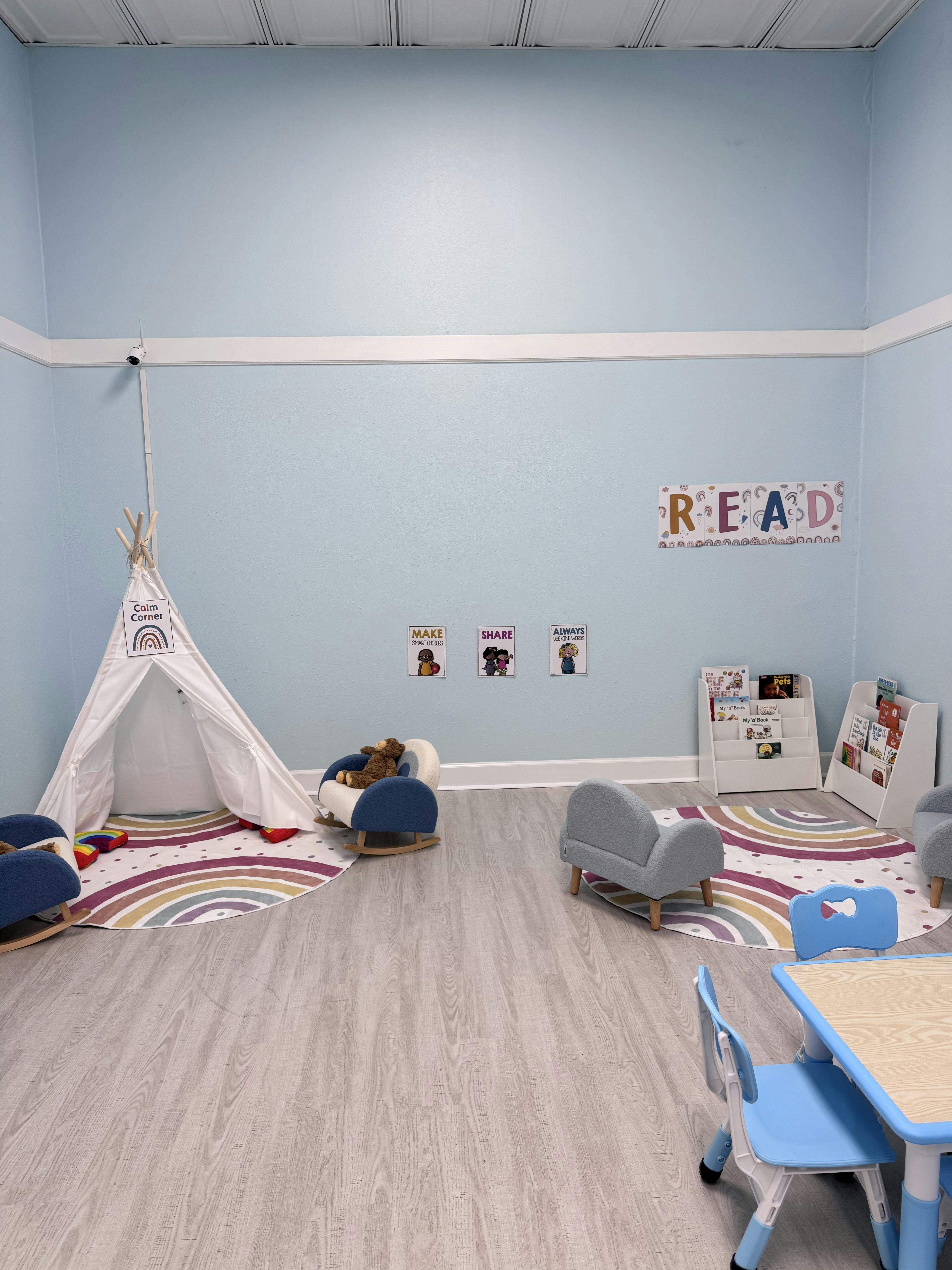 Children's play area with a teepee, small chairs, and a table