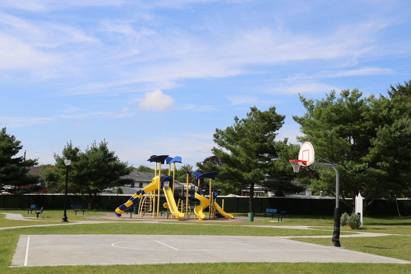 Playground with yellow slides and a basketball court