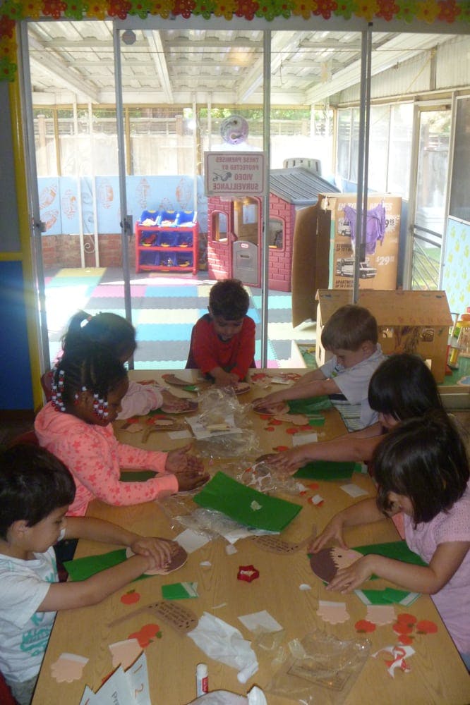 Children sitting at a table doing crafts in-class activities