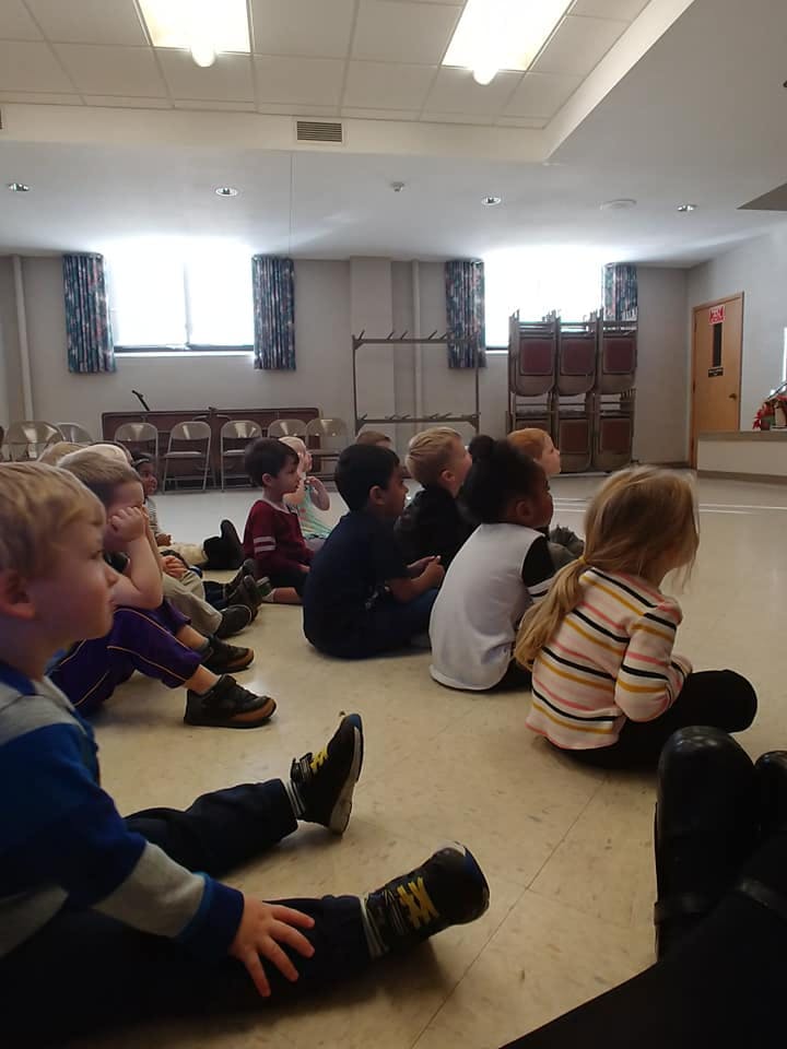 Group of children sitting on the floor looking forward