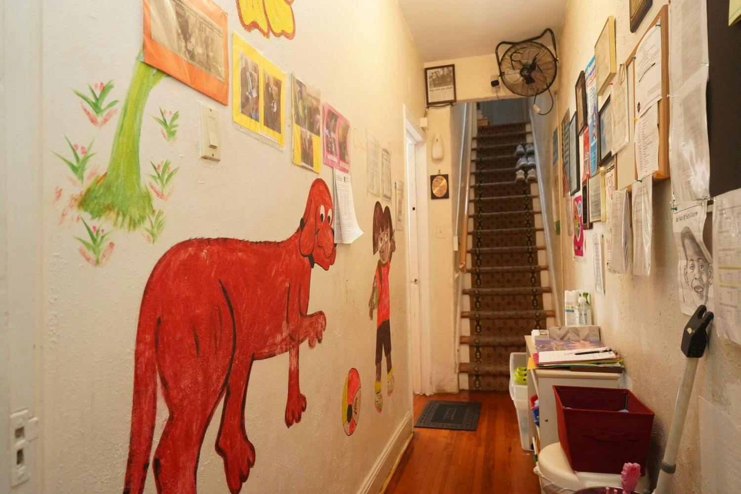 Hallway with children's drawings on the wall and a staircase