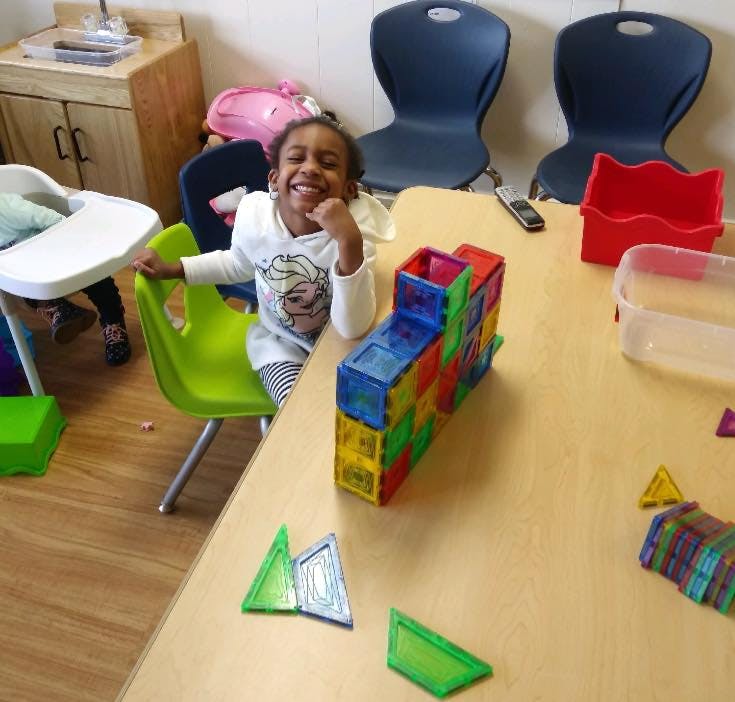 Child sitting at a table with colorful building blocks