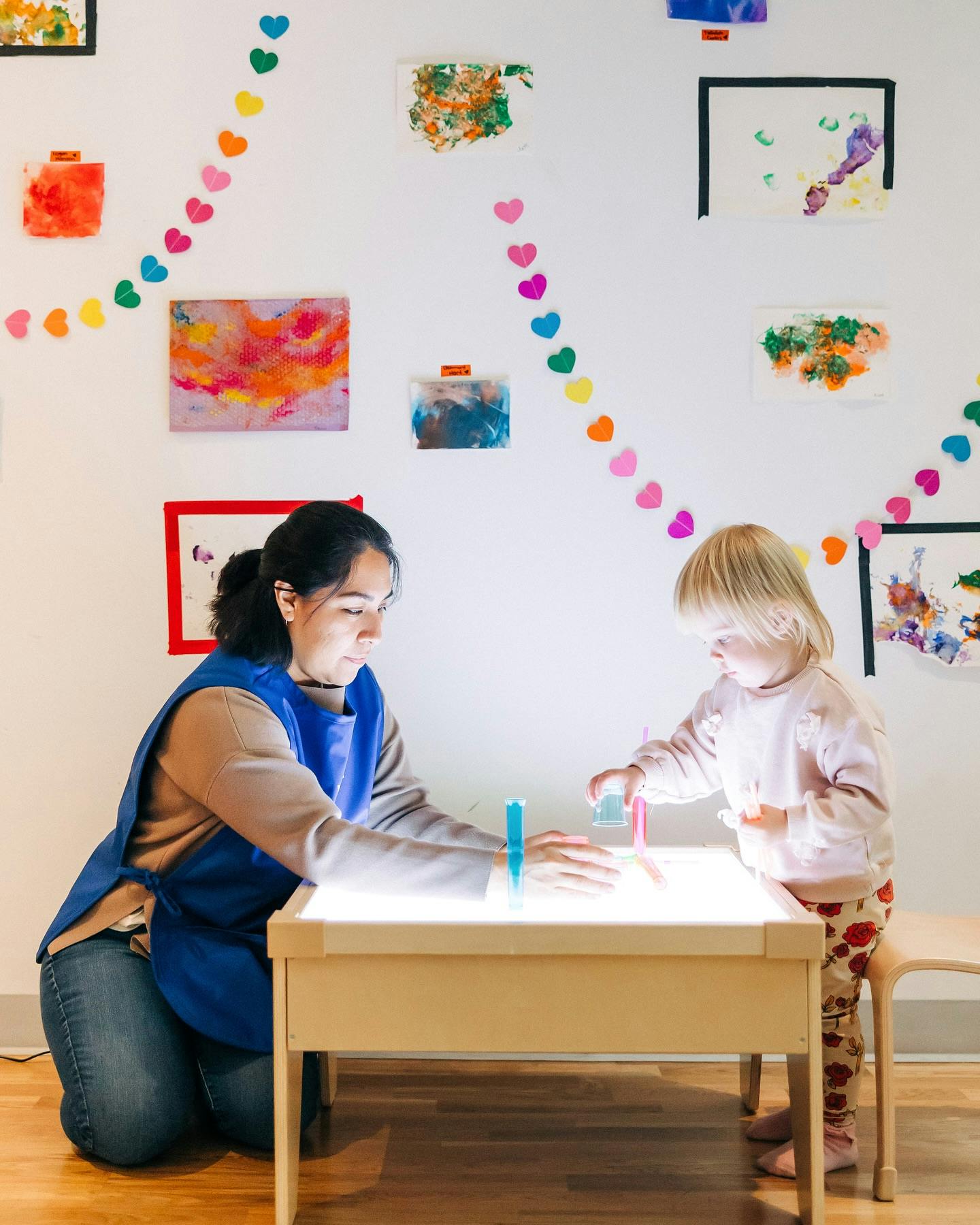 Person and child playing with light table