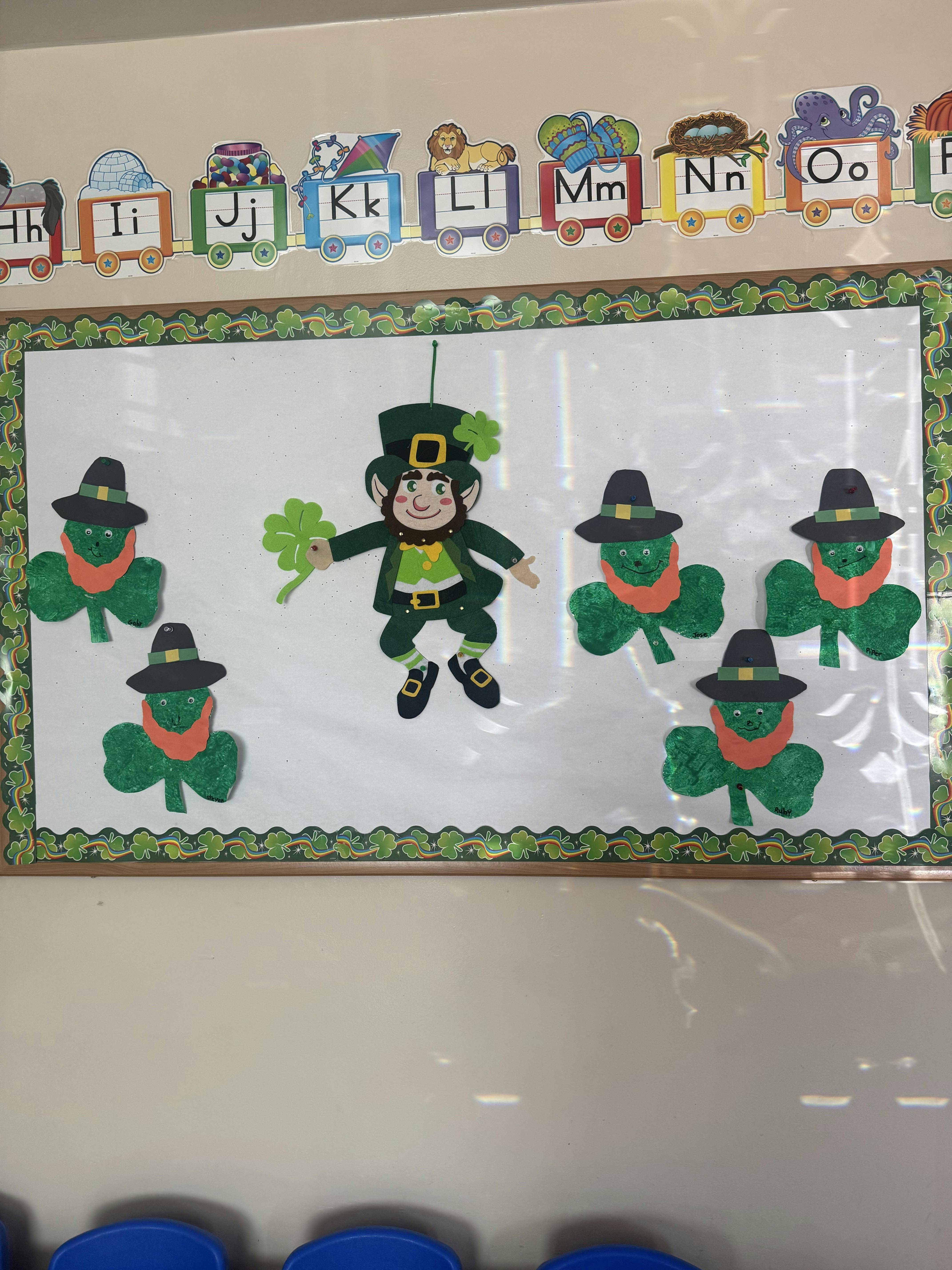 Classroom bulletin board with a leprechaun and several shamrock characters