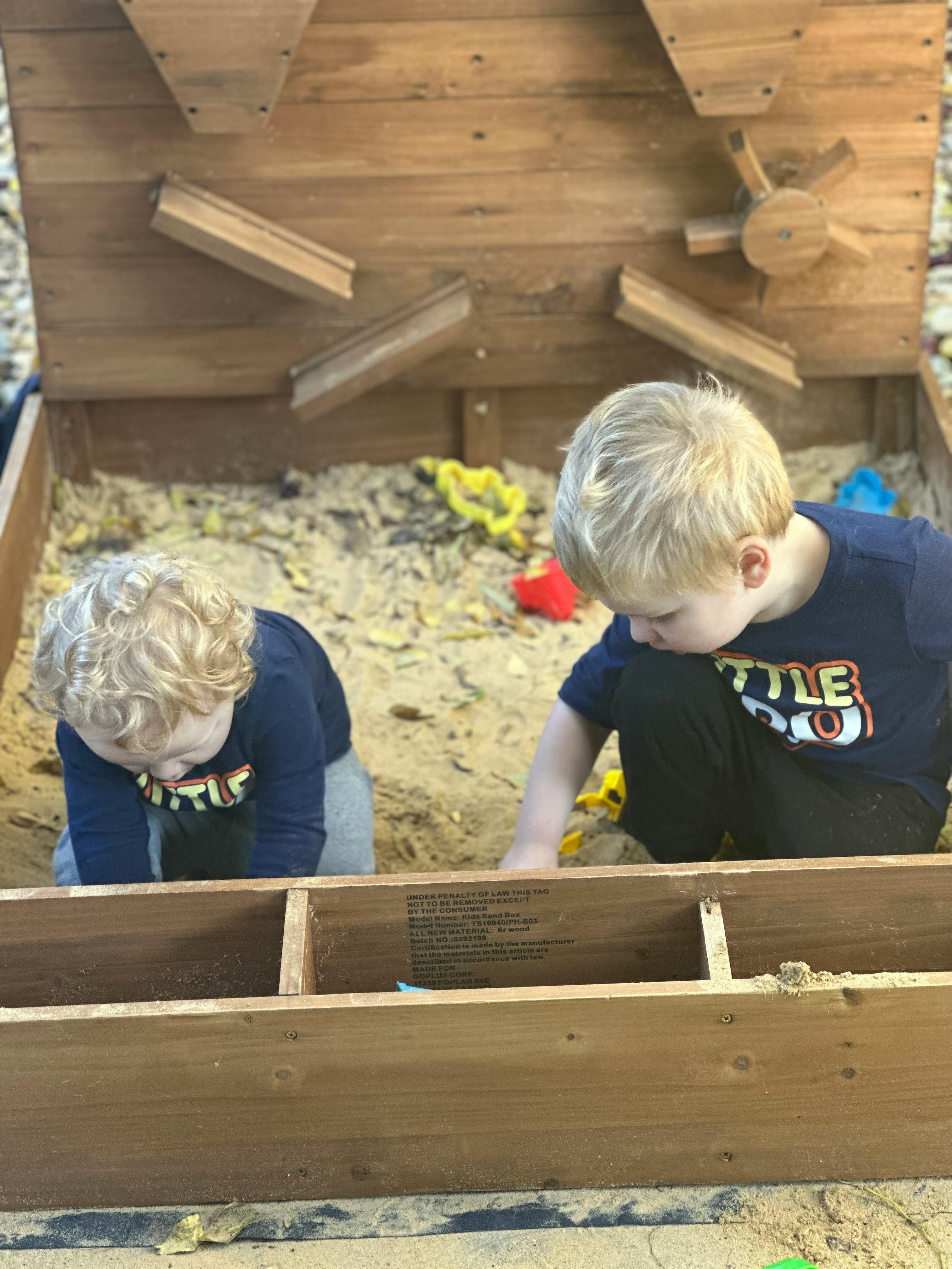 Two children playing in a sandbox