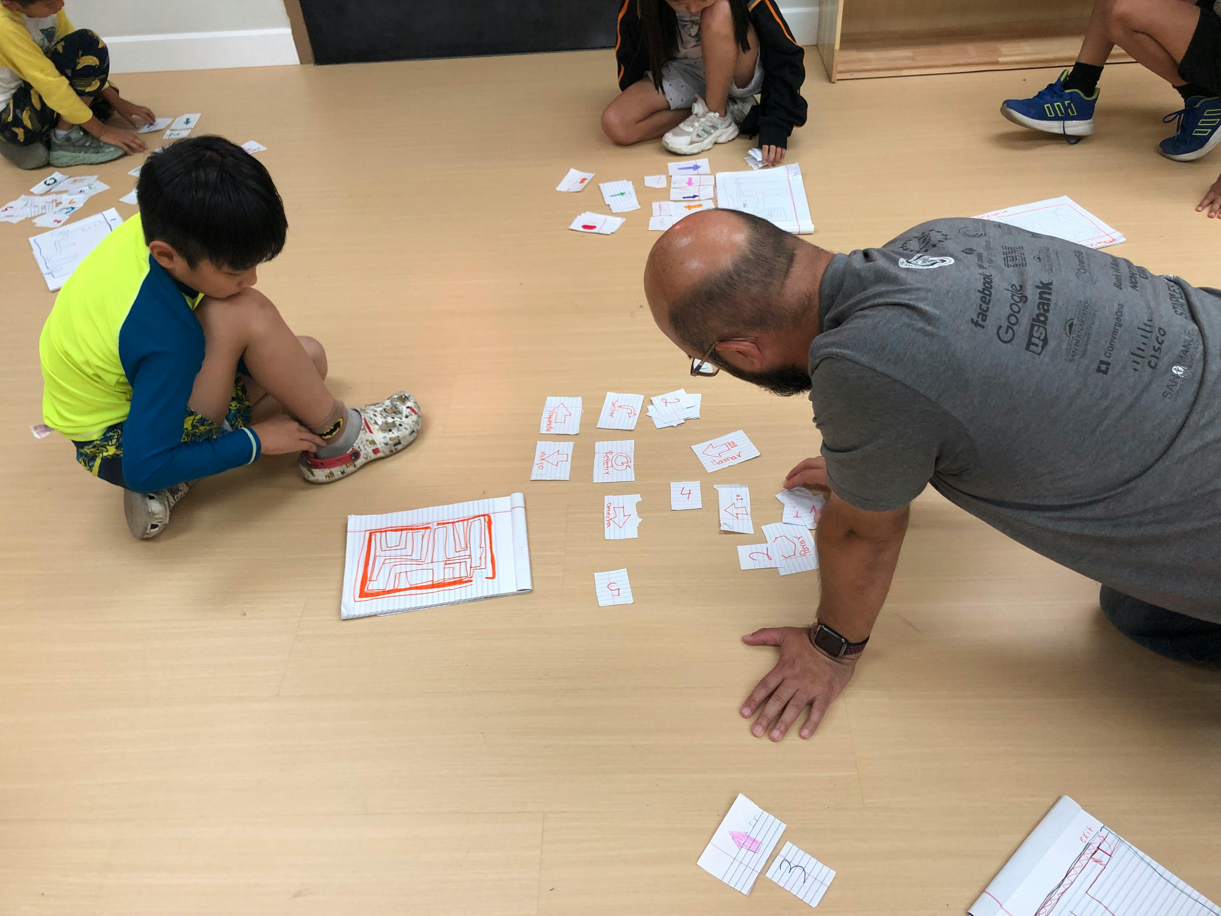 Adult and child on floor looking at small cards