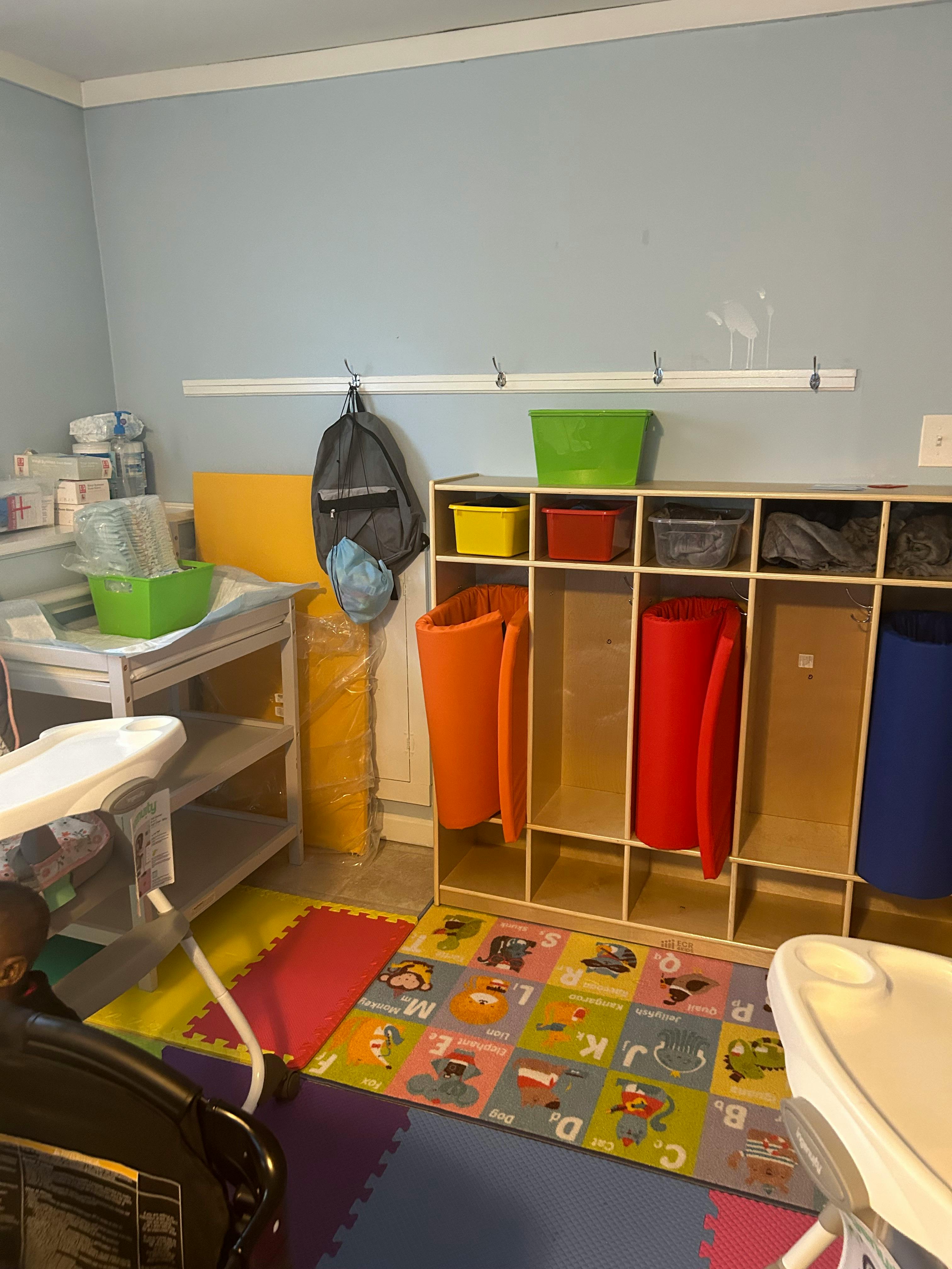 Childcare room with cubbies, changing table, and play mats