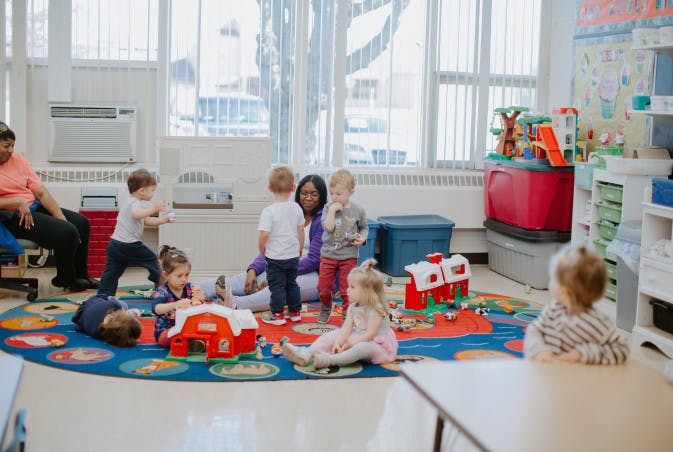 Children and adults playing with toys in a classroom