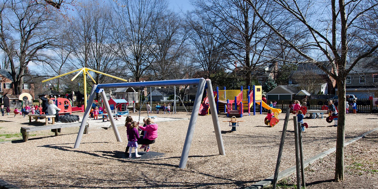 Children playing on swings and other equipment in a playground
