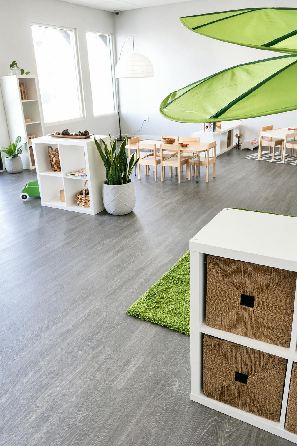 Spacious playroom with wooden tables and storage shelves