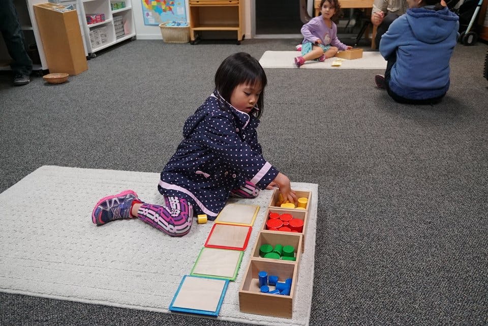 Child playing with colorful blocks in a classroom