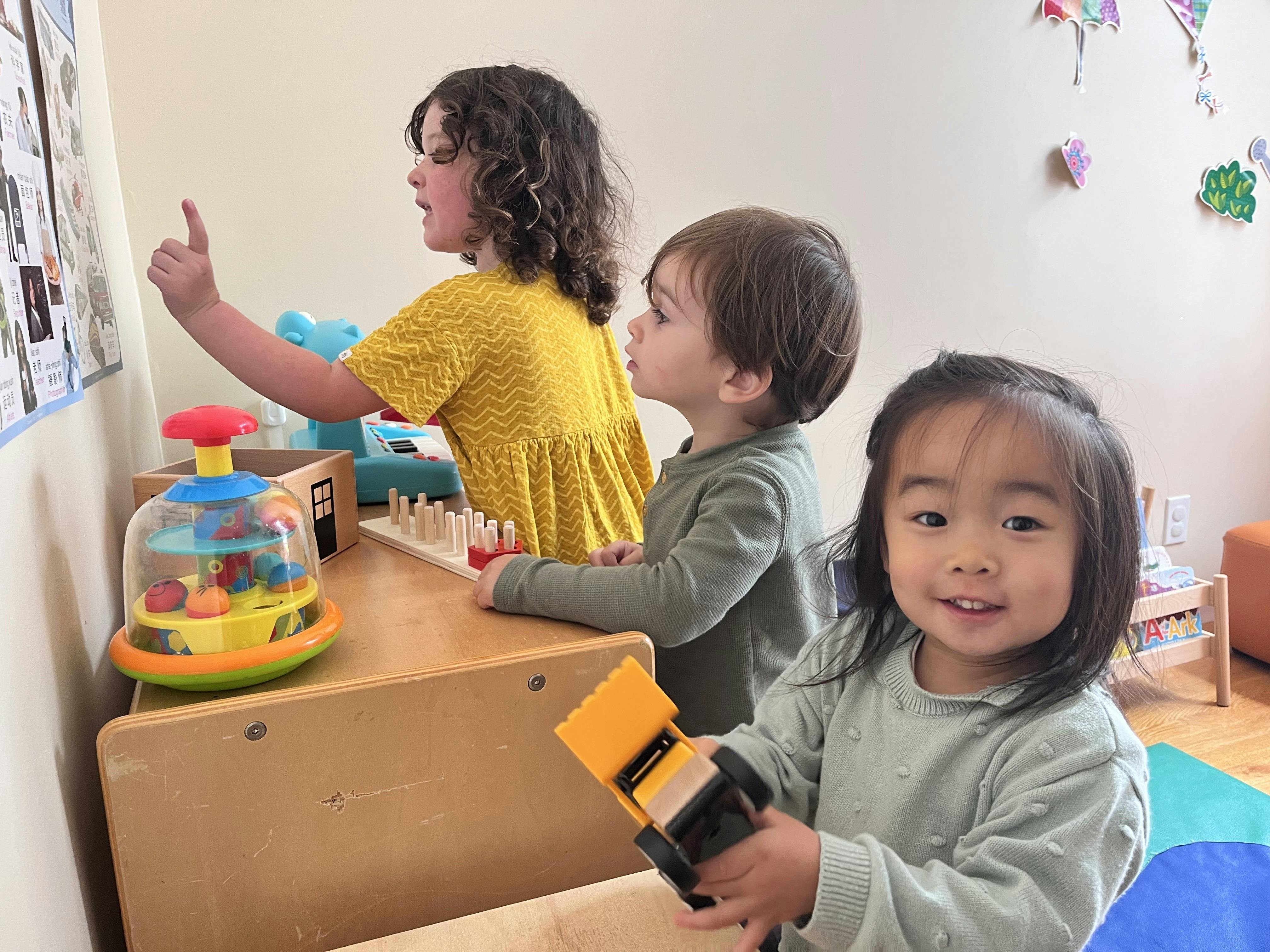 Three children playing in a classroom