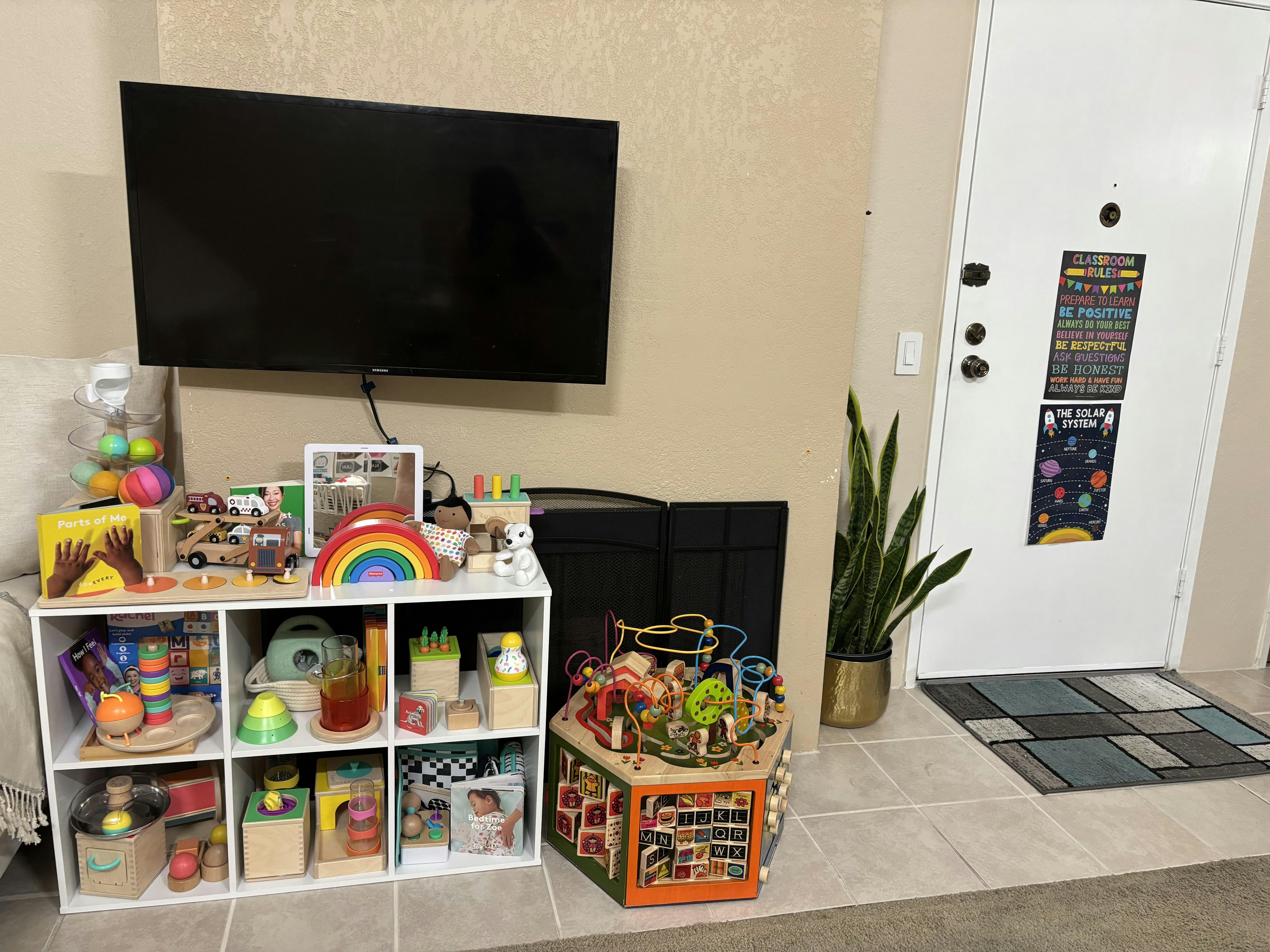 TV mounted above a cubby shelf filled with children's toys and books