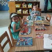 Two children at a table with books
