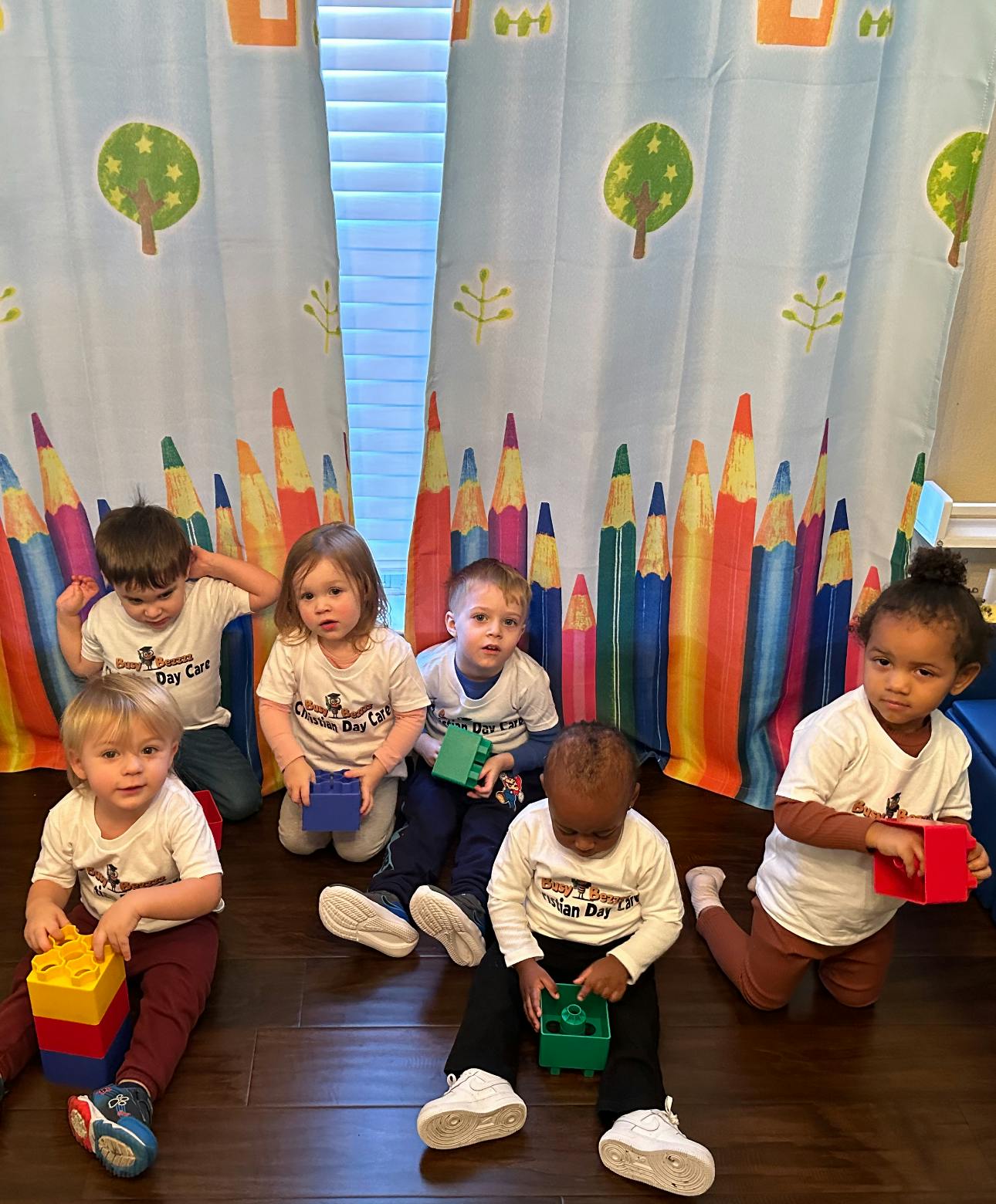 Group of children sitting on the floor playing with blocks