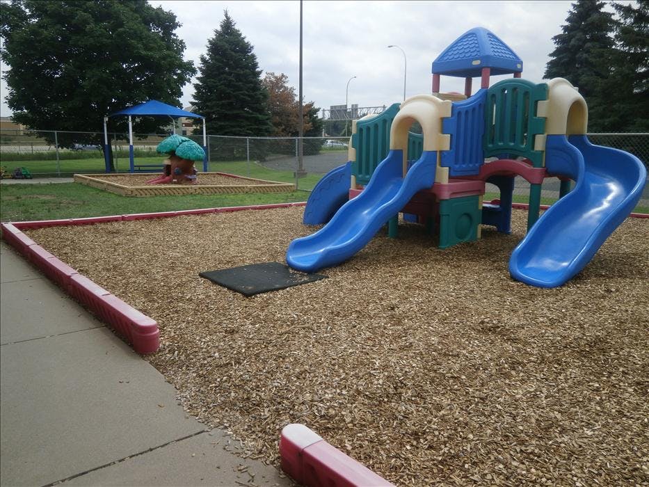 A colorful playground with slides and a covered seating area
