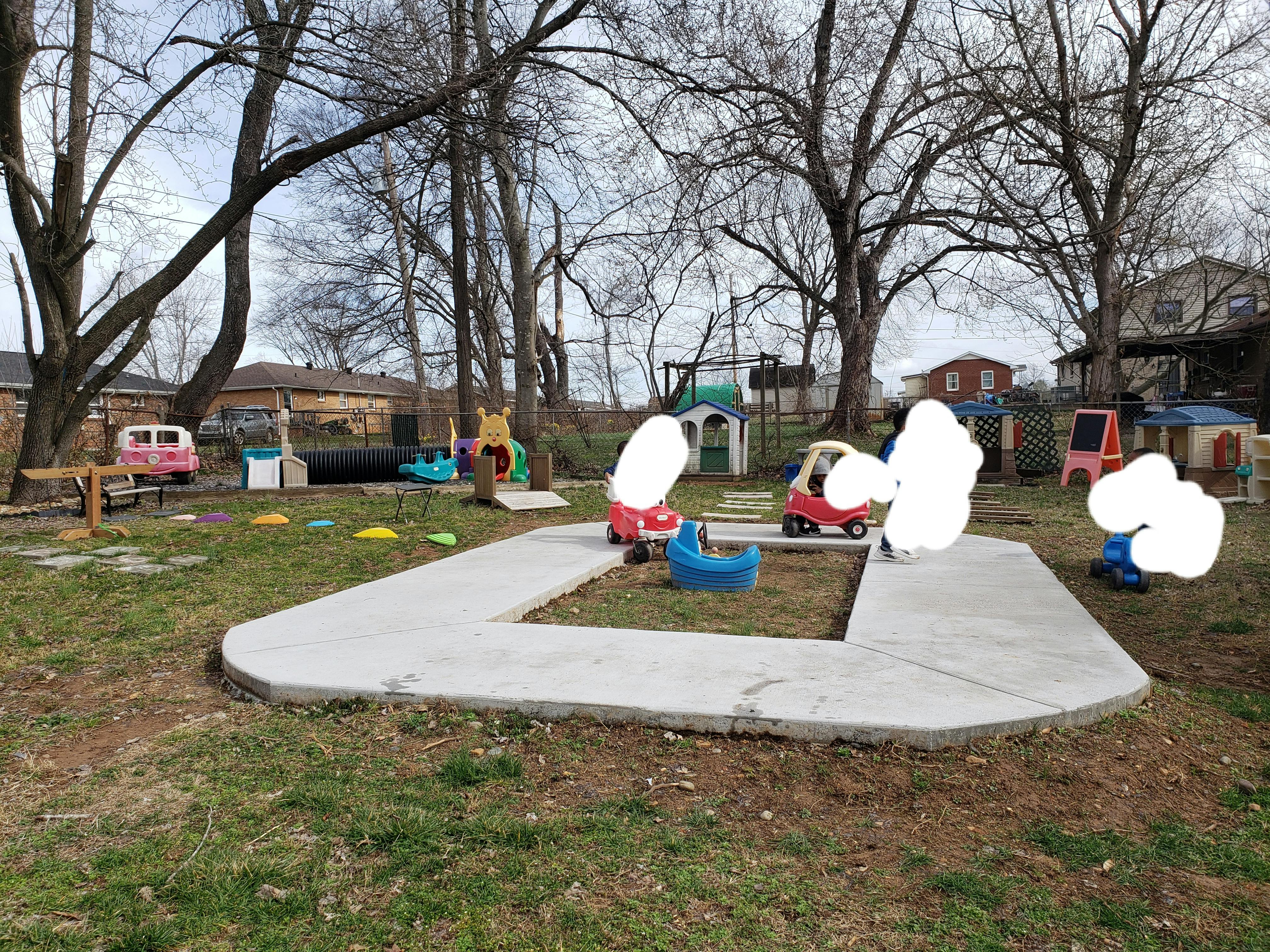 Outdoor play area with ride-on toys and playhouses
