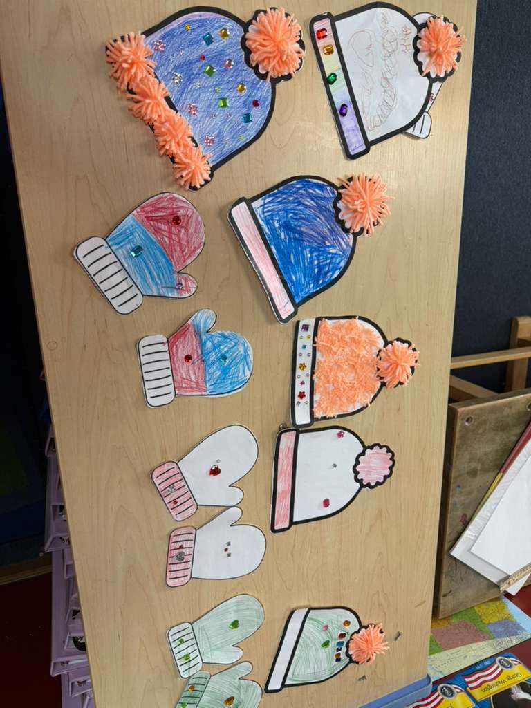 Childlike drawings of winter hats and mittens with pom-poms and sequins