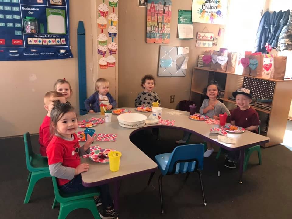 Children sitting at a table in a classroom