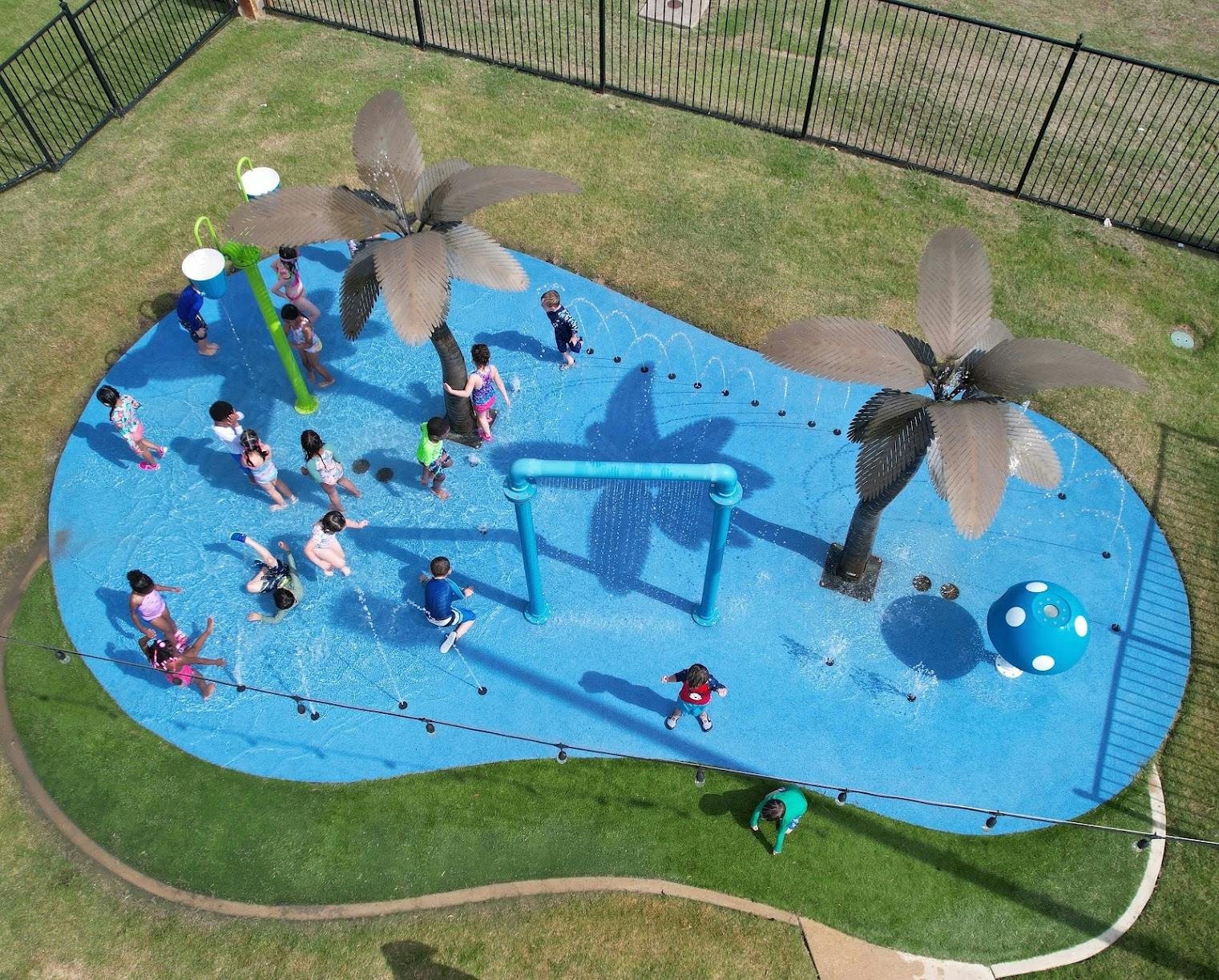 Children playing in a splash pad with water features
