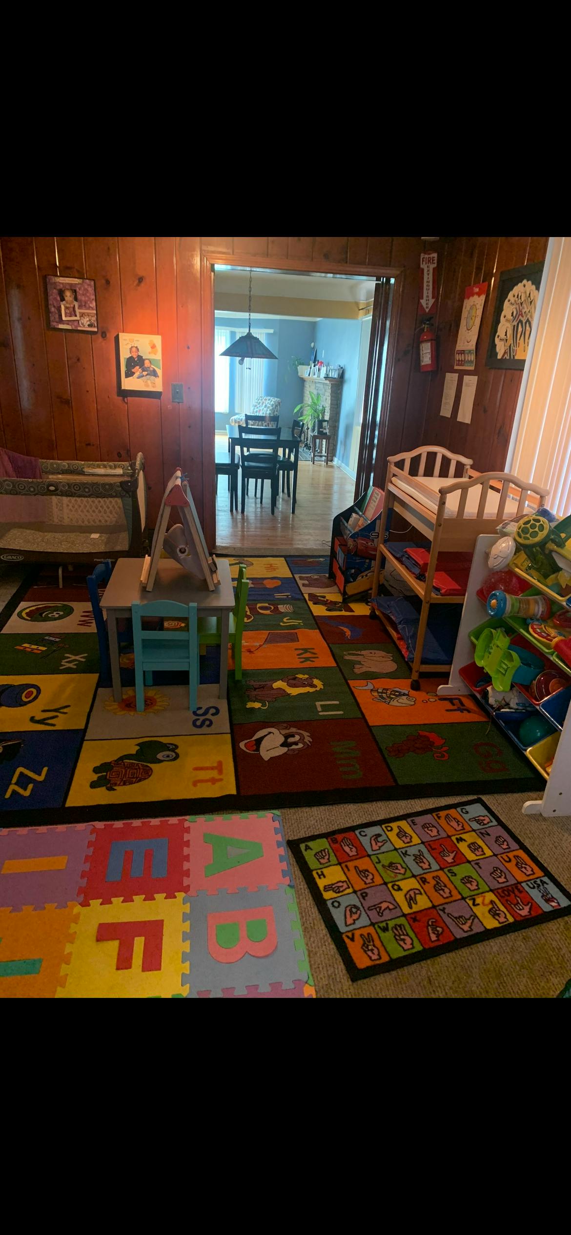 Playroom with alphabet rugs, child-sized furniture, and toy storage units