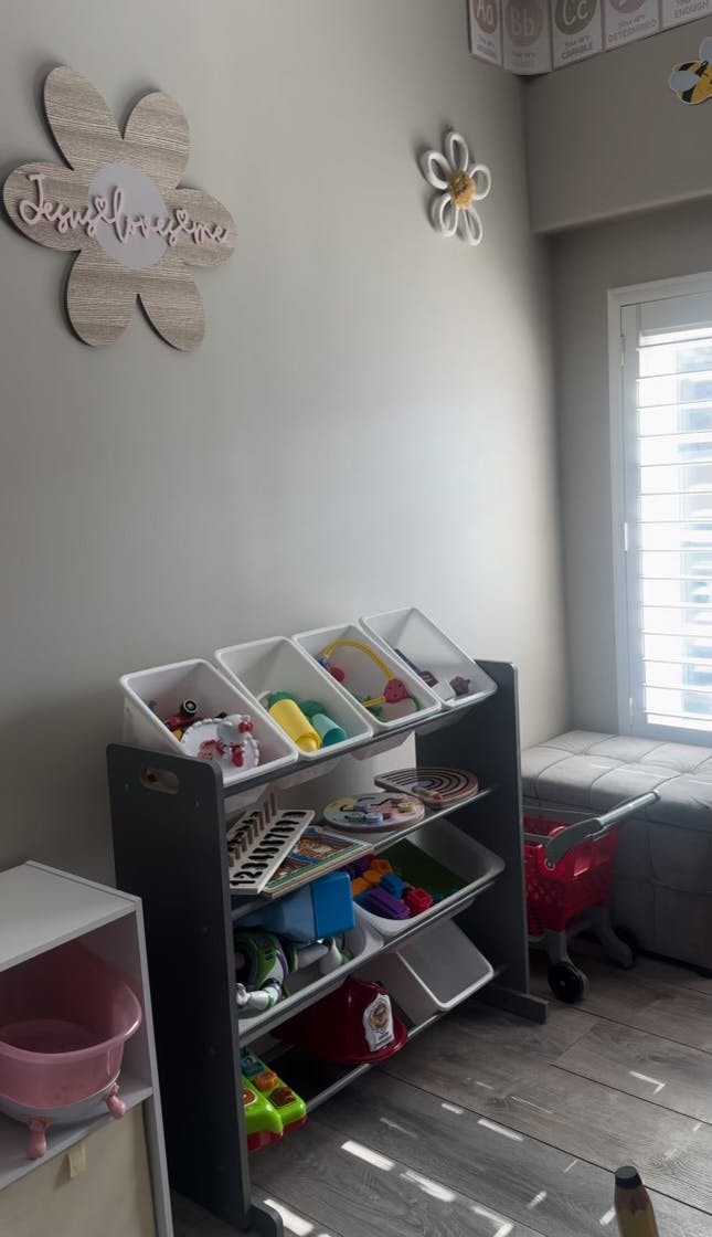 Toy storage unit with bins filled with various toys