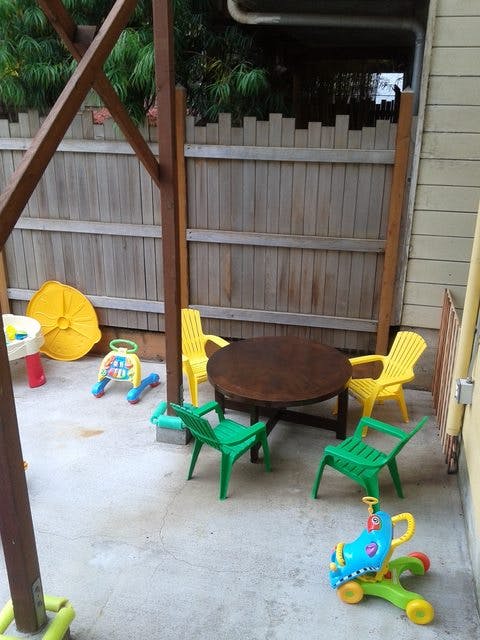Patio with a round table, chairs, and children's toys