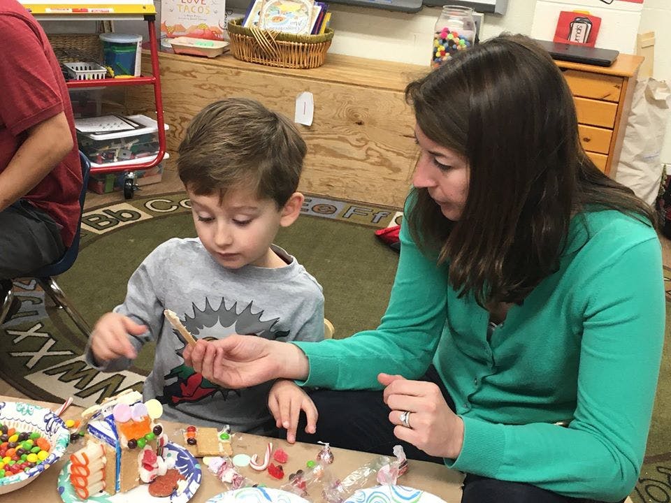 Adult and child decorating small gingerbread houses