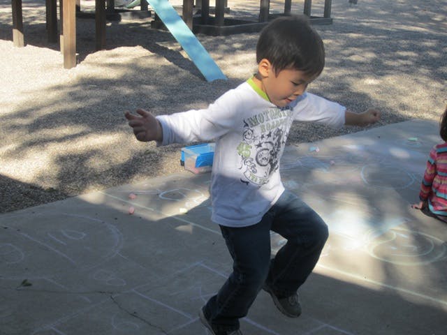 Child playing hopscotch on a playground