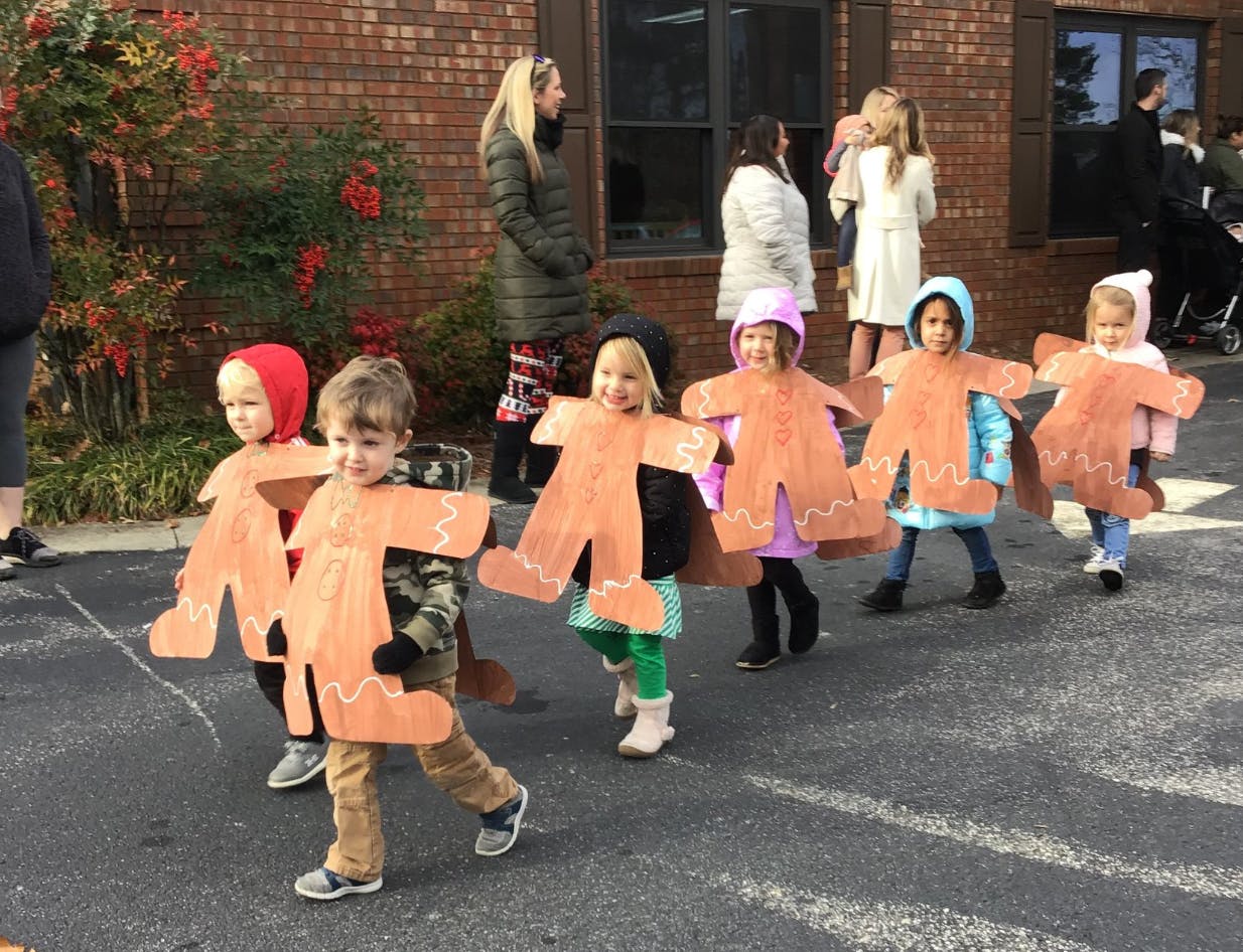 Children in gingerbread person costumes walking outdoors
