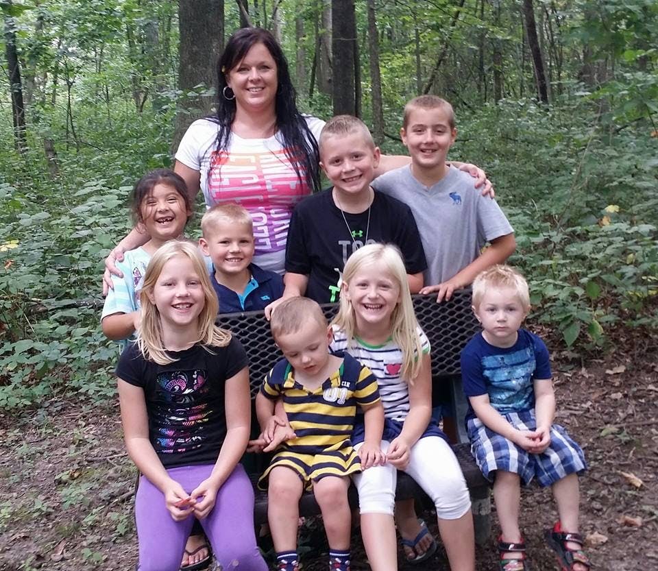 Adult and multiple children posing outdoors