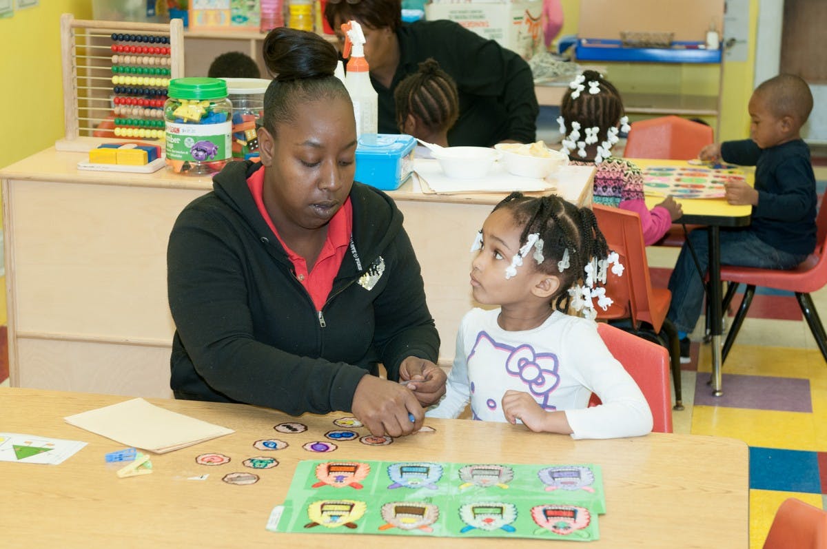 Adult and child at a table with learning materials