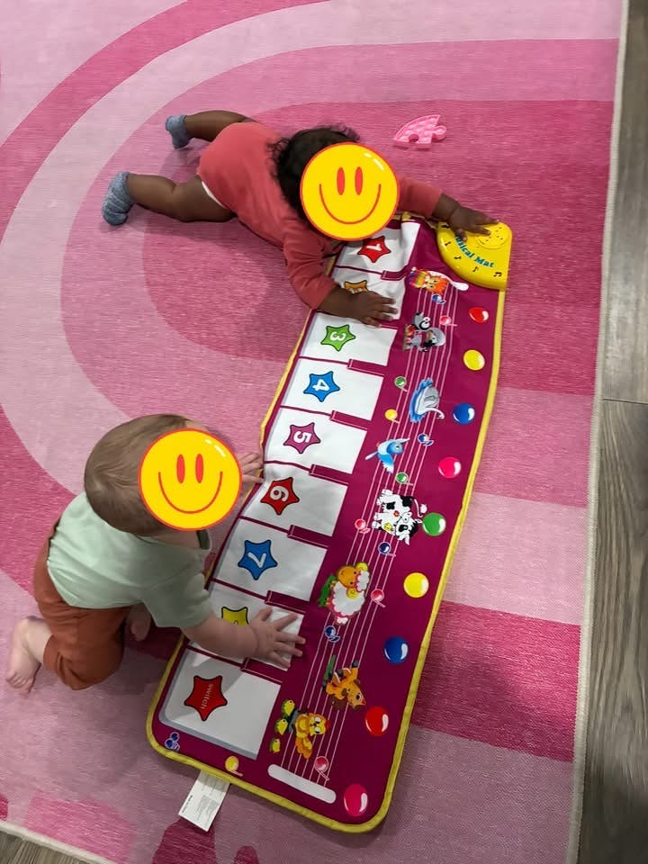 Two children playing on a floor musical mat