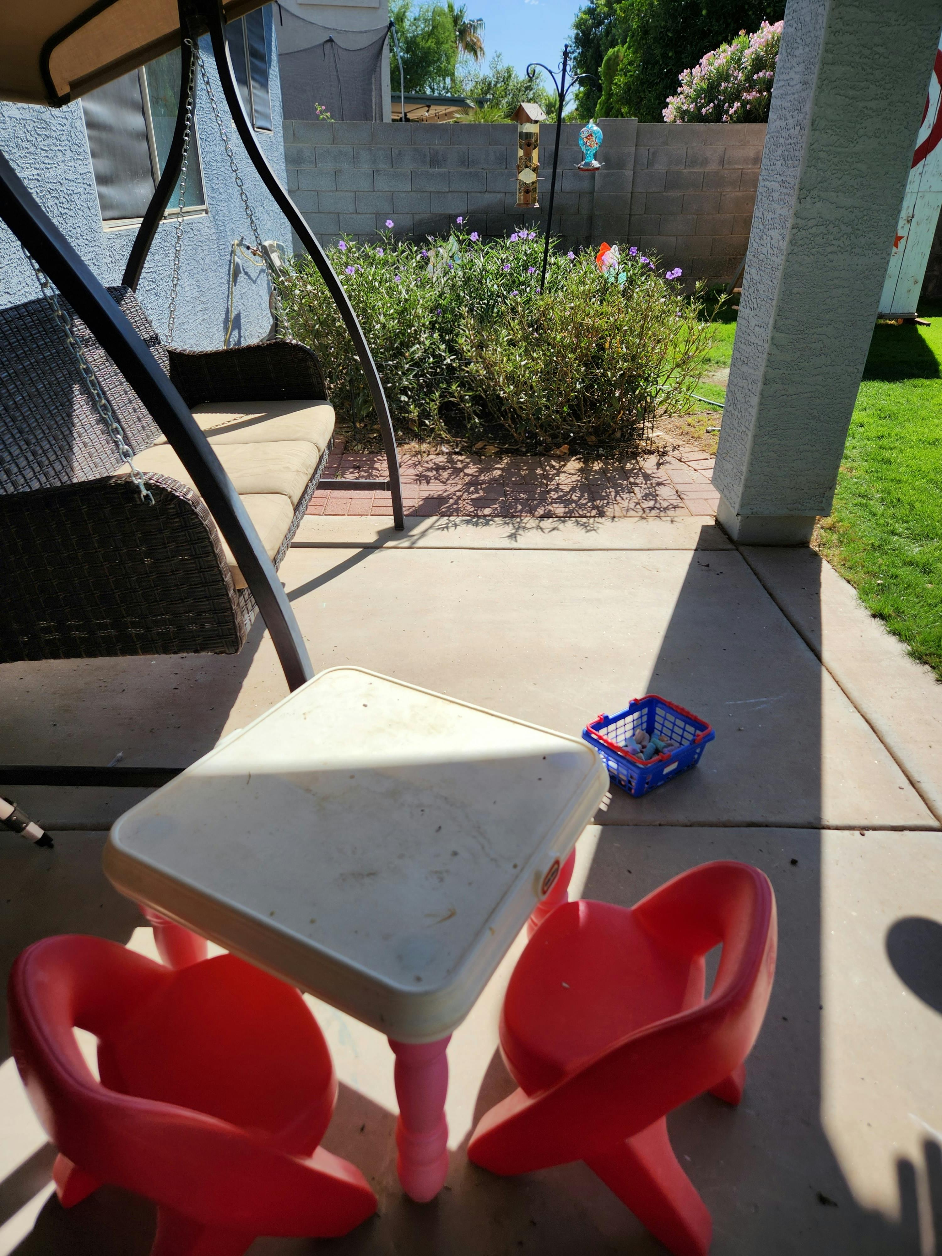 Small table with two red chairs on a patio