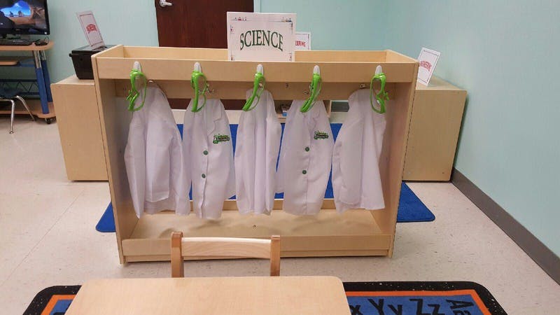 Science lab coats hanging on a rack in a classroom