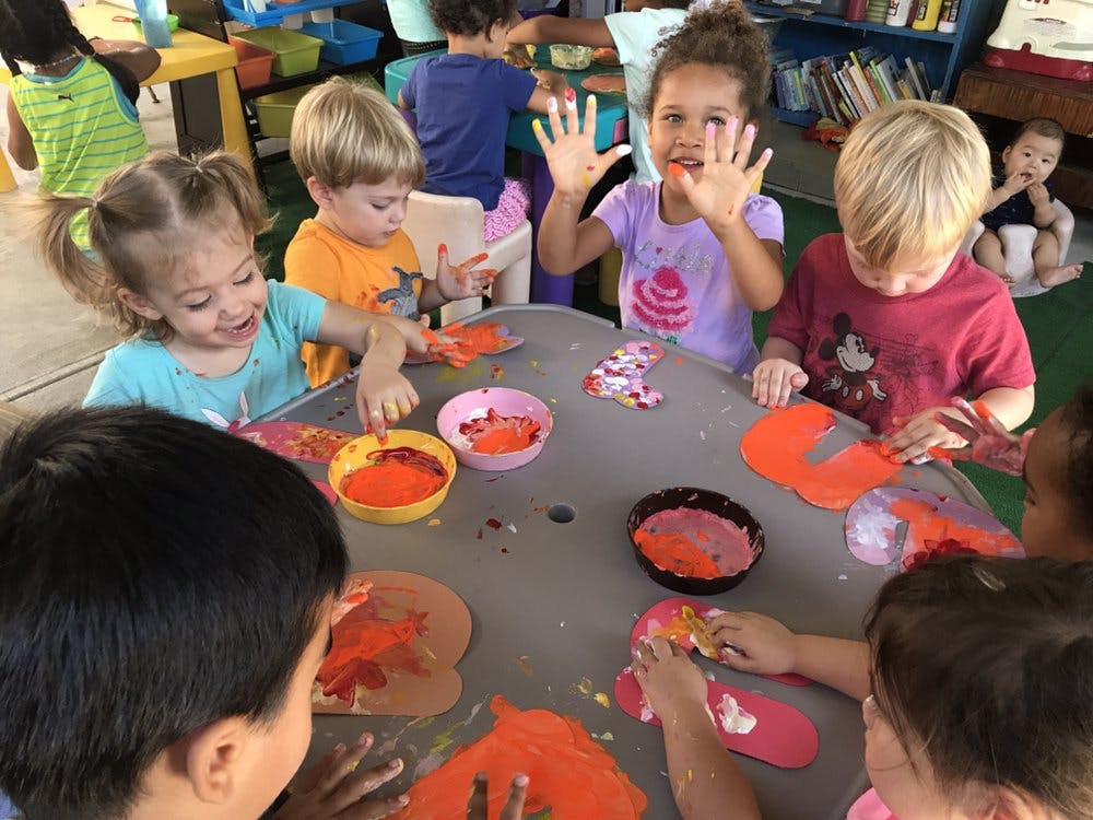Children doing a craft project with paint at a table