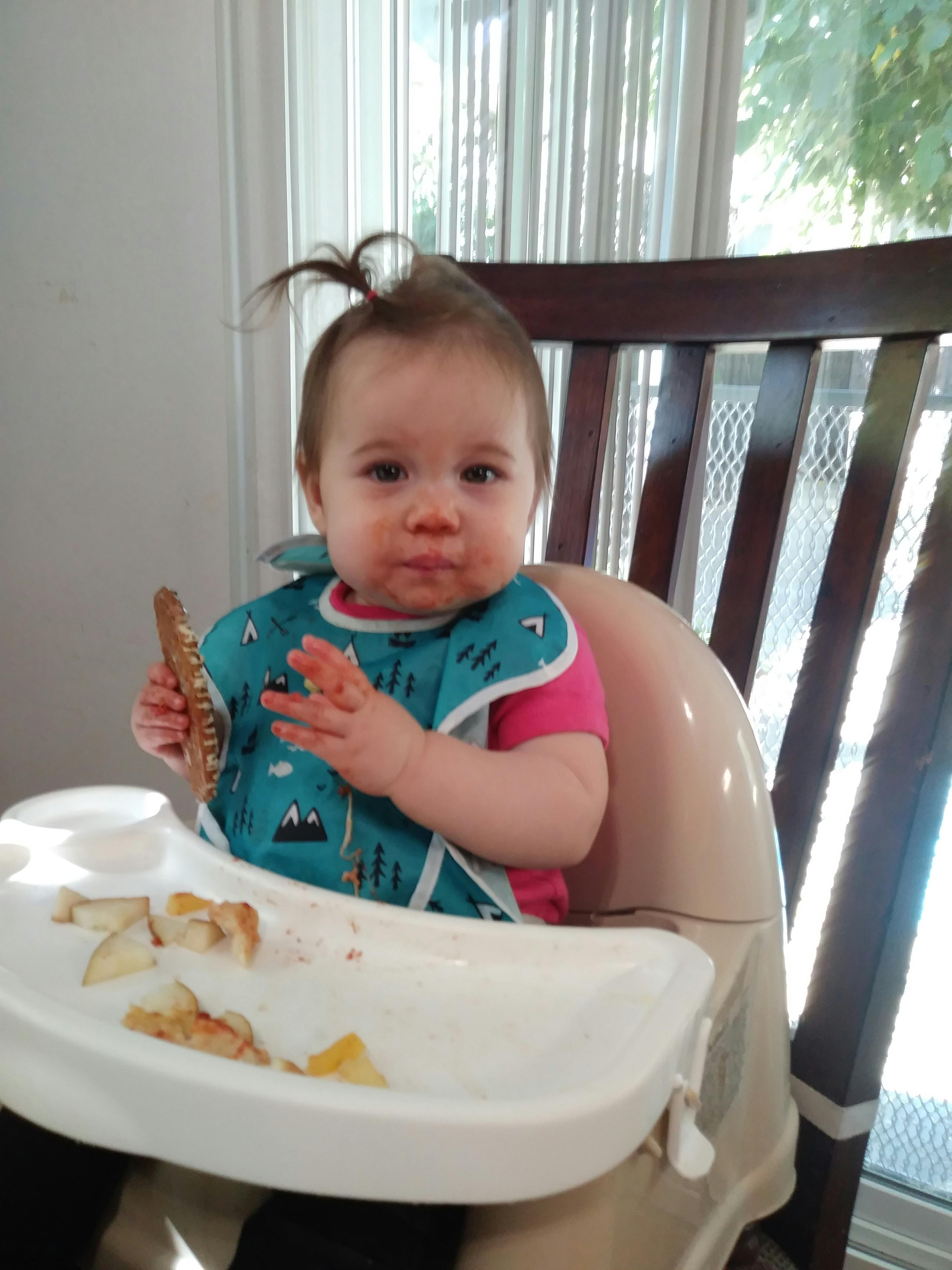 Child in a high chair with food on the tray