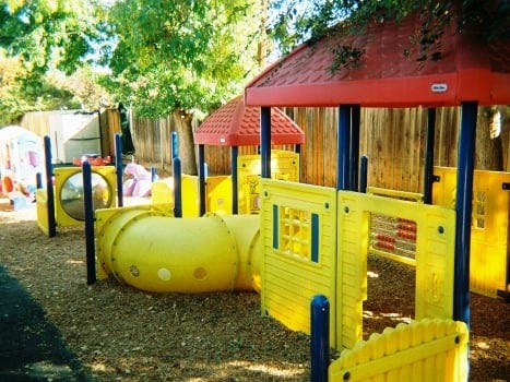 Yellow and red playground equipment with tunnels and structures