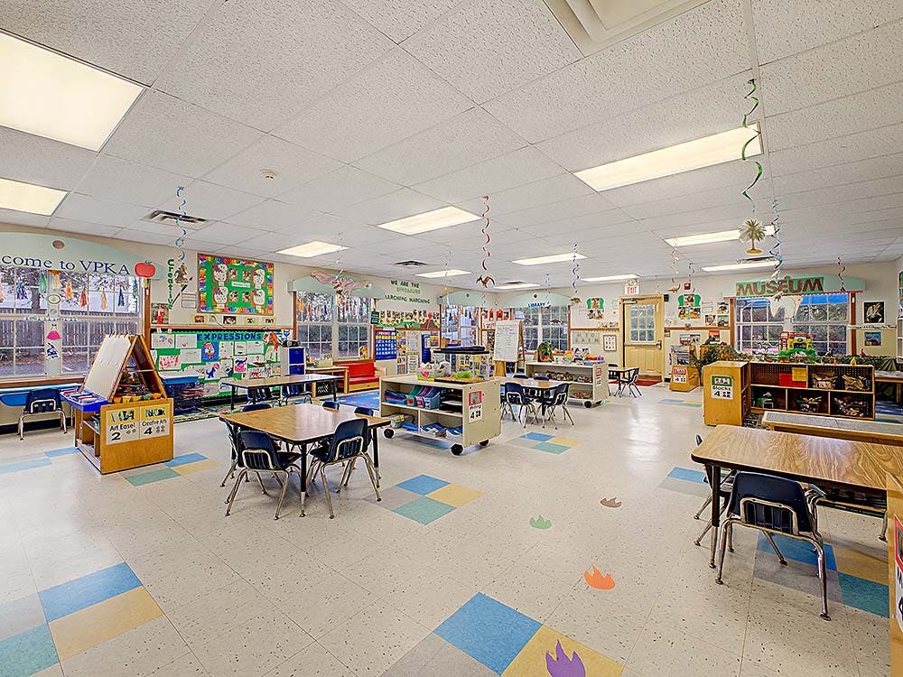 Empty colorful classroom with small tables and chairs