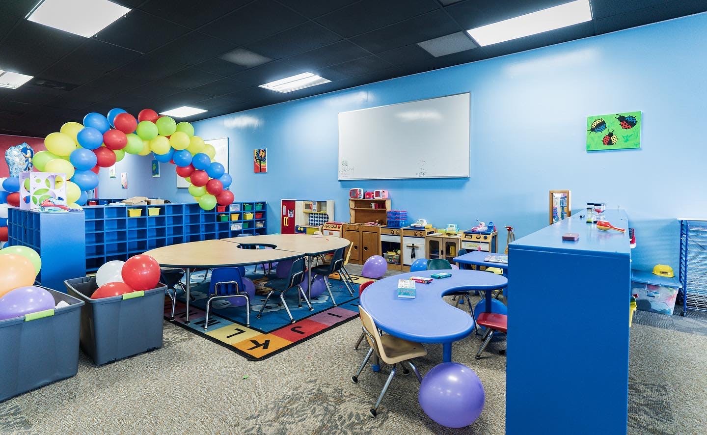 Classroom with tables, chairs, and a balloon arch