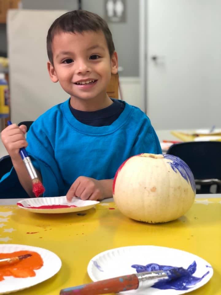 Child painting a pumpkin