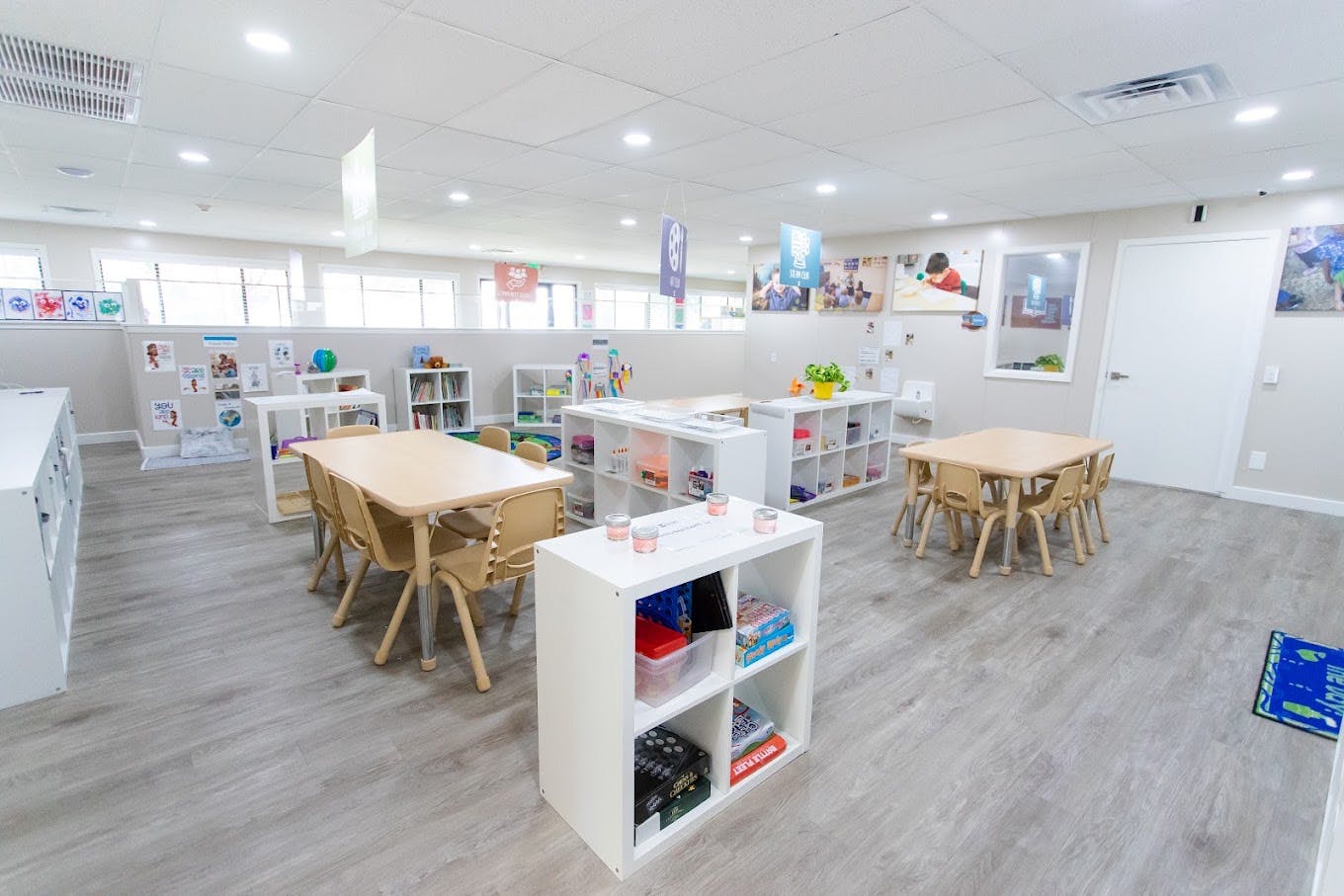 Classroom with child-sized tables and chairs and storage shelves
