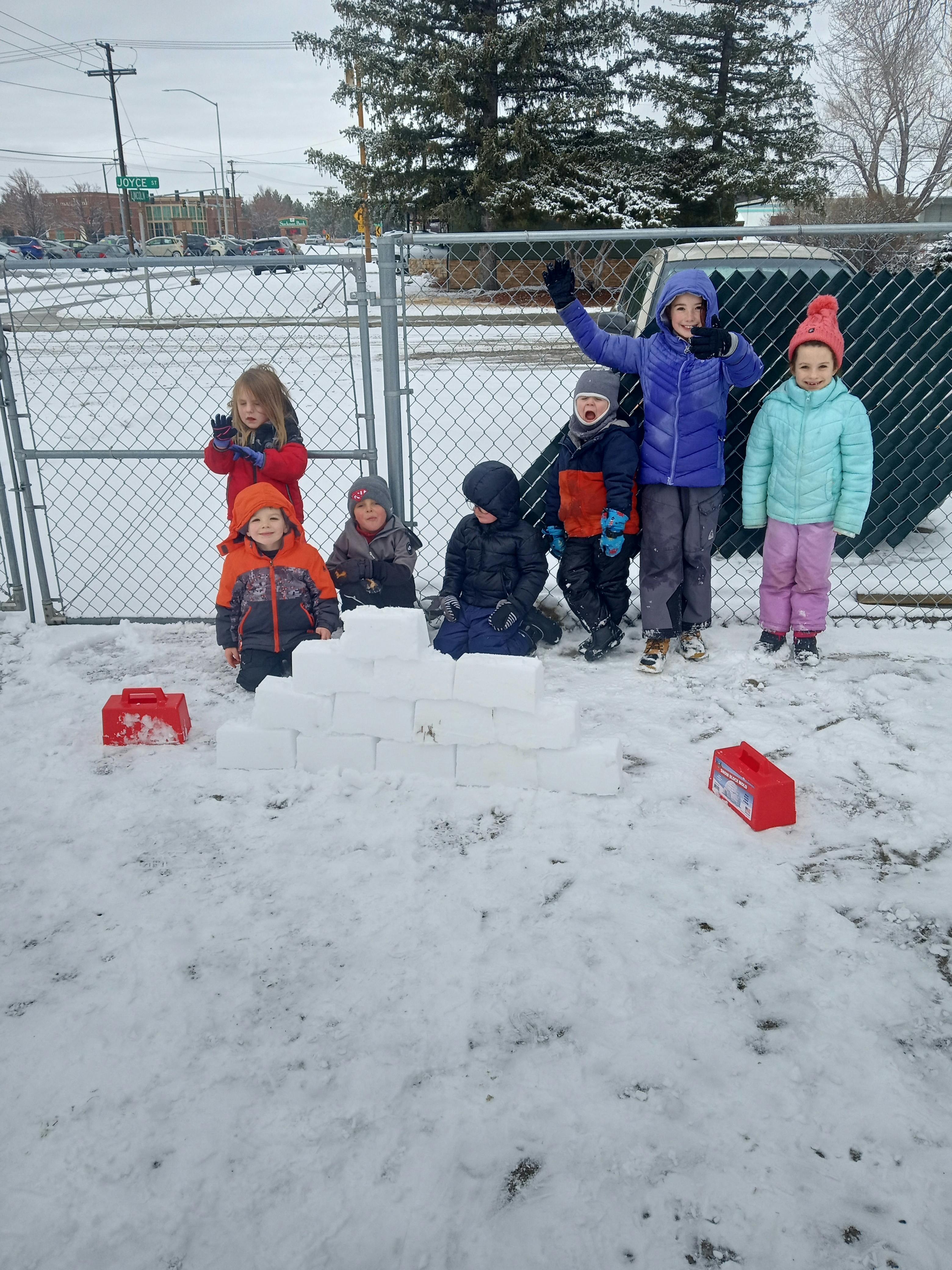 Children playing in the snow, building with snow blocks