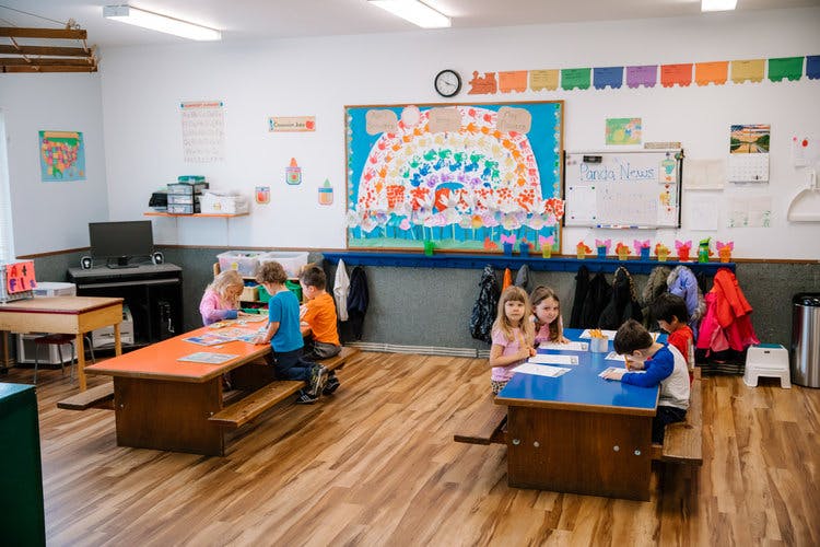 Children sitting at tables in a classroom